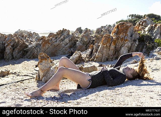 Teenage girl relaxing on the sand on a beach