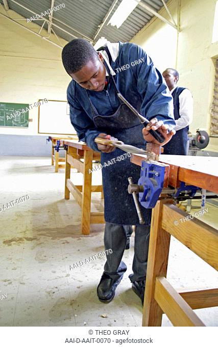 School boy sawing in woodwork classroom, St Mark's School, Mbabane, Hhohho, Kingdom of Swaziland
