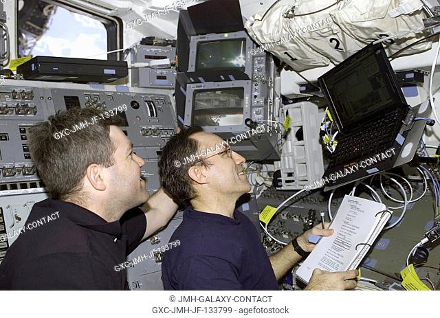 Astronauts Stephen N. Frick (left), STS-110 pilot, and Carl E. Walz, Expedition Four flight engineer, work with Payload and General Support Computers (PGSC) on...