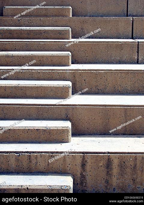 OLYMPUS DIGITAL CAMERAModern outdoor concrete ascending steps with raised area for seating in contrasting sunlight and shadow
