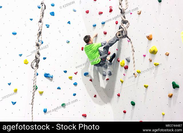 Rear view of man climbing wall without any protection