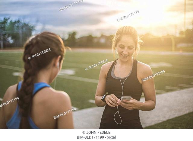 Athletes listening to mp3 players on sports field