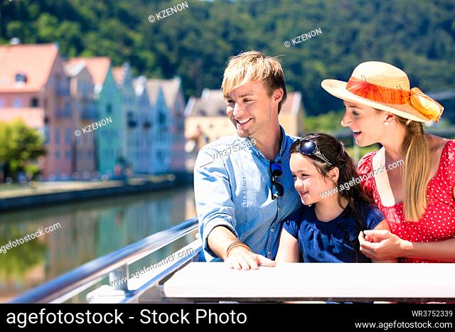 Happy family on river cruise in summer sitting in ship