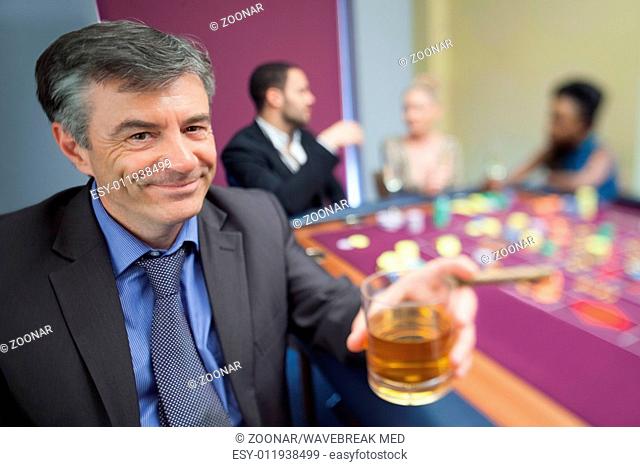 Man with whiskey glass at roulette table