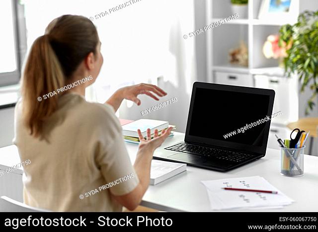 treacher with laptop having video call at home