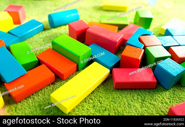 Colorful wooden blocks for children on green carpet