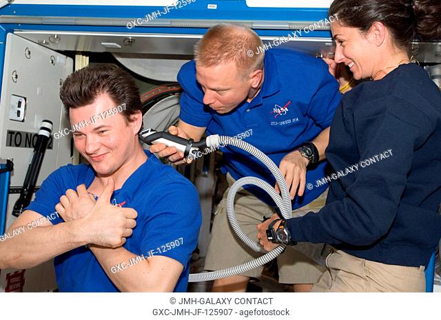 NASA astronaut Tim Kopra, STS-128 mission specialist, trims Russian cosmonaut Roman Romanenko's hair in the Destiny laboratory of the International Space...