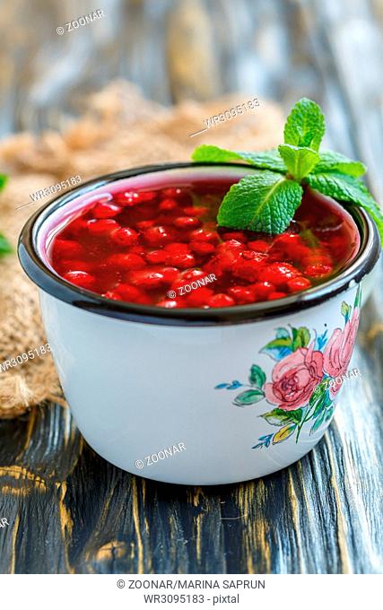 Cranberry jelly and green mint in an enamel mug