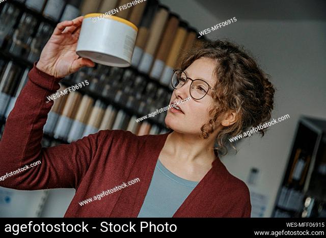 Young female customer reading label on product in retail store
