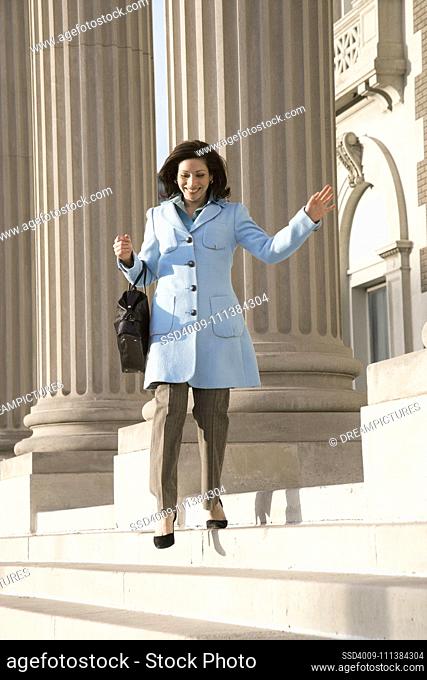 Hispanic businesswoman walking down steps