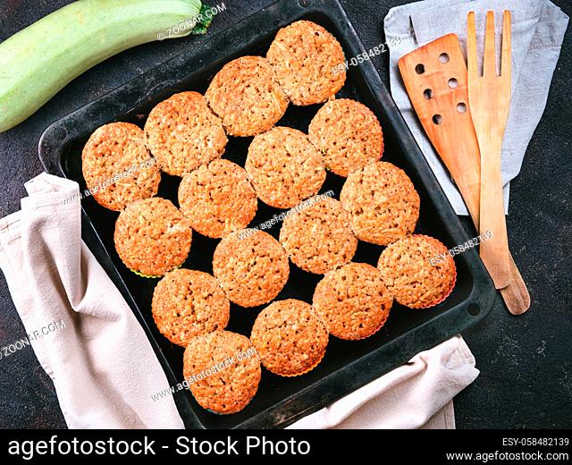 Top view of baking tray with homemade vegetables muffins. Cupkace with zucchini, carrots, apple and cinnamon on black cement background