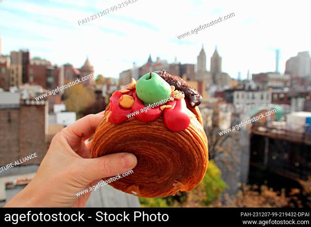 17 November 2023, USA, New York: A woman holds two ""Suprêmes"" - similar to croissants, filled with apple-caramel cream (front) and chocolate cream (back)