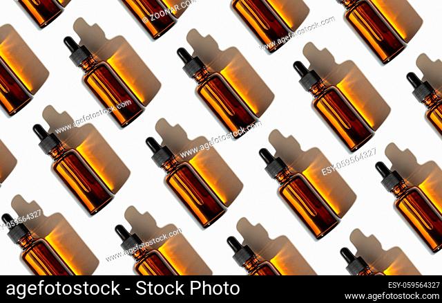 Essential oil or serum glass bottle pattern isolated on white background. Copy space