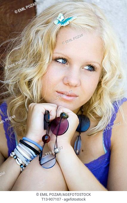Young woman blonde portrait with small peg butterfly in her hair