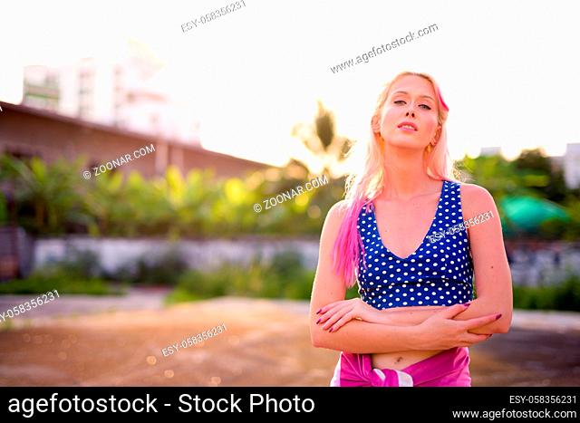 Portrait of young beautiful blonde woman exploring the city streets outdoors