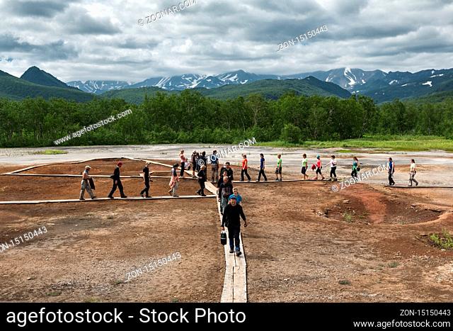 NALYCHEVO, KAMCHATKA, RUSSIA - JULY 30, 2014: Tourists walk on wooden deck, overlooking Thermal Pad Boiler, or Travertine Shield Boiler