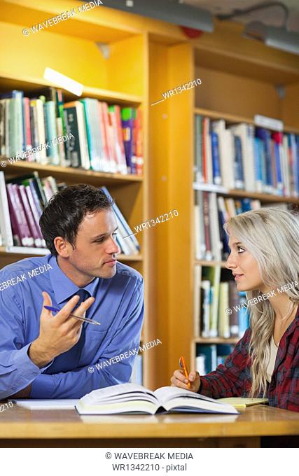 Lecturer explaining something to attentive blonde student