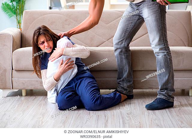 Desparate wife with aggressive husband in domestic violence concept