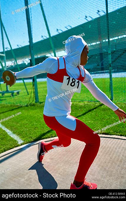 Atleta de pista y campo femenino en hijab lanzando disco
