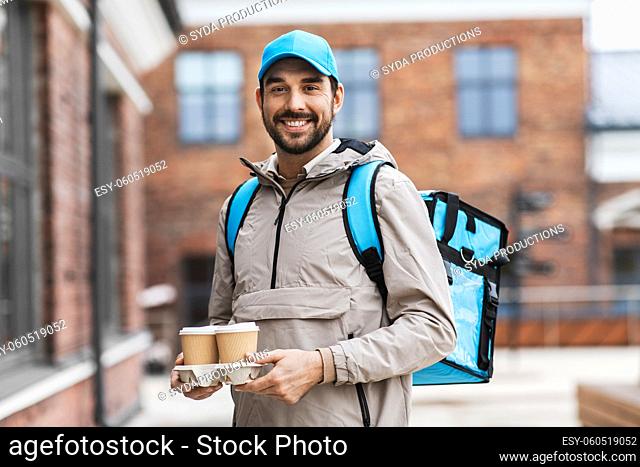 happy delivery man with thermal bag and coffee