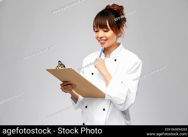 smiling female chef with clipboard and pen