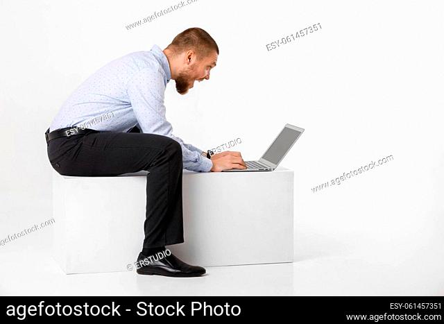happy surprised handsome businessman in shirt using laptop against white background