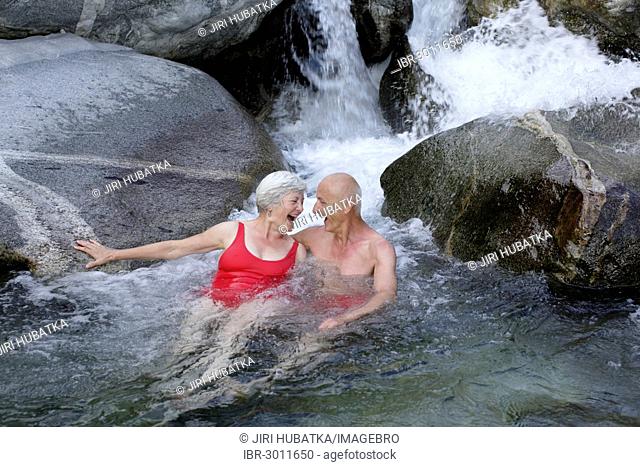 Couple, 59 and 68 years, bathing in the mountain river of Torrente Codera