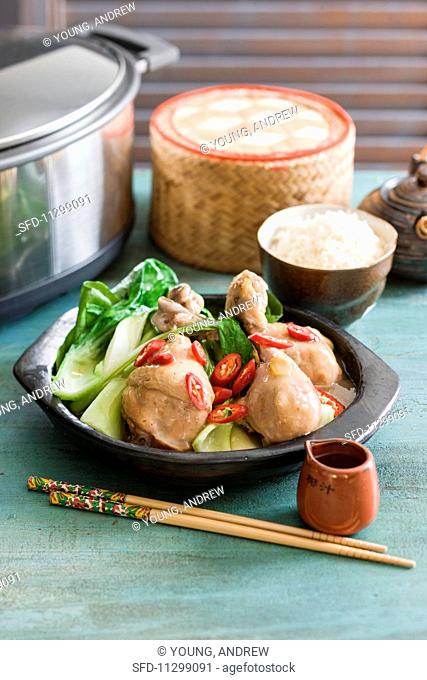 Spicy braised chicken with ginger and soy sauce served with bok choy and rice
