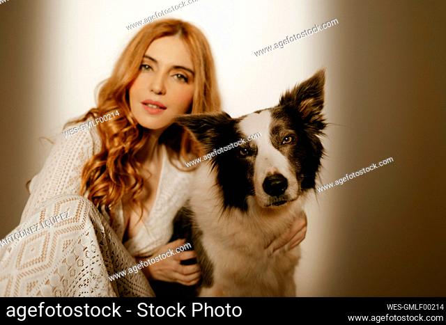 Blond woman at home in pijama with a border collie dog