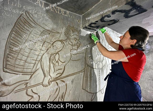 27 July 2022, Thuringia, Jena: Katharina Heiling, graduate restorer for wall painting and architectural surfaces, is working in the historical carcass of the...