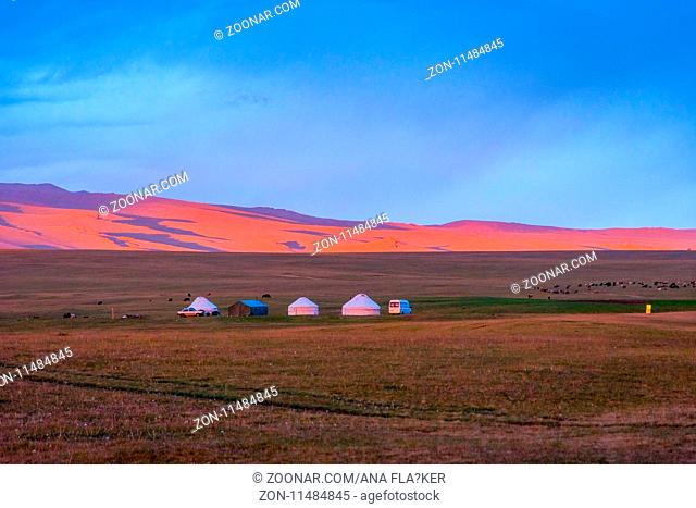 Yurts and mountains around Song Kul lake in a sunset light, Kyrgyzstan