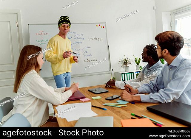 Businessman giving presentation to colleagues at office