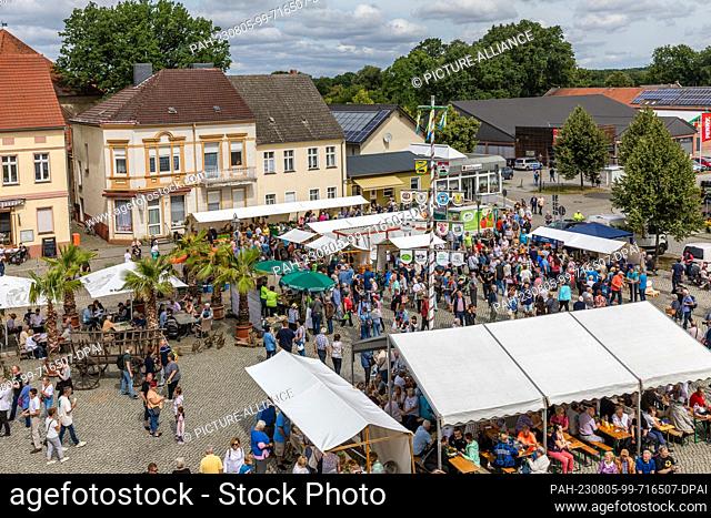 05 August 2023, Brandenburg, Golßen: Numerous people walk through the market at the Spreewald Gherkin Day in Golßen. At numerous sales booths