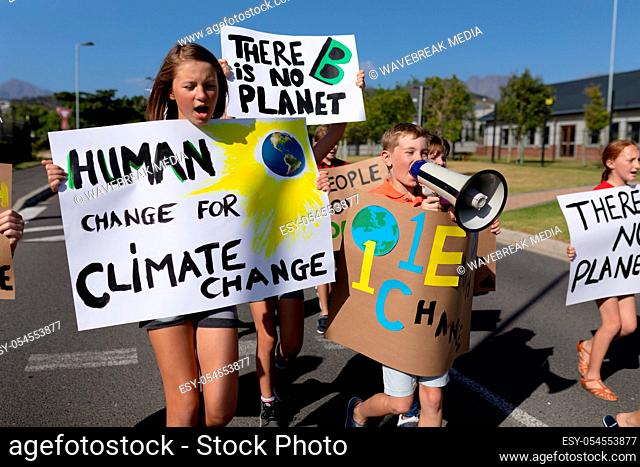 Front view close up of a group of Caucasian elementary school pupils on a protest march, carrying signs with environmental and conservation slogans on them