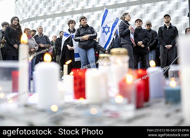 12 October 2023, Saxony, Leipzig: Participants of a rally stand behind lit candles in the center of Leipzig. The rally is held in solidarity with Israel