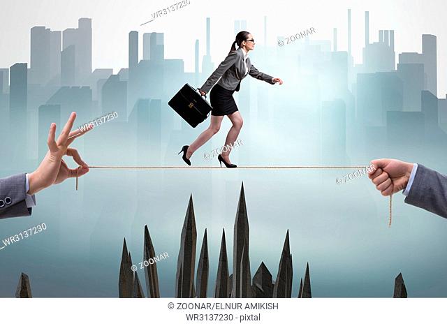Businesswoman walking on tight rope in business concept