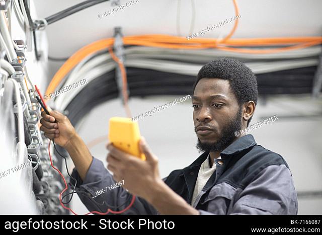 Young technician works in the building as a building technician in the basement