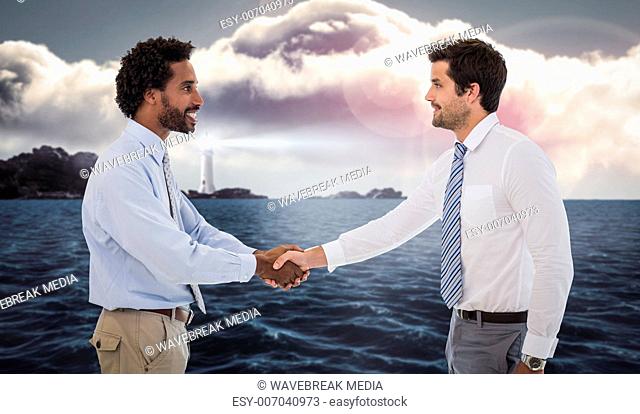 Composite image of smiling young businessmen shaking hands in office