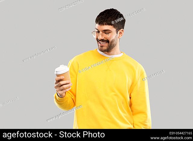smiling young man with takeaway coffee cup