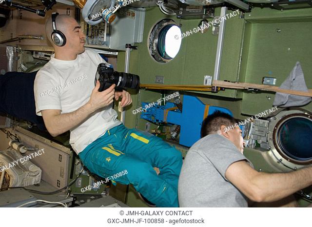 From windows in the International Space Station's Zvezda Service Module, Russian cosmonauts Anatoly Ivanishin (left) and Oleg Kononenko