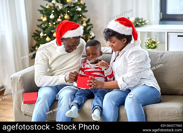 african family opening christmas gift at home