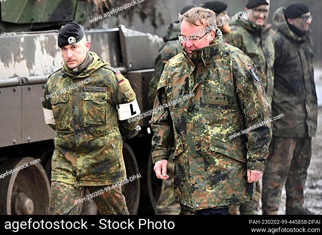 01 February 2023, North Rhine-Westphalia, Augustdorf: Boris Pistorius (SPD, r), Minister of Defense, walks with a soldier past a Leopard 2A6 of the German...