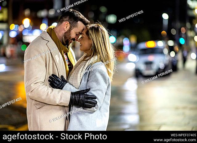 Happy man and woman embracing each other on road