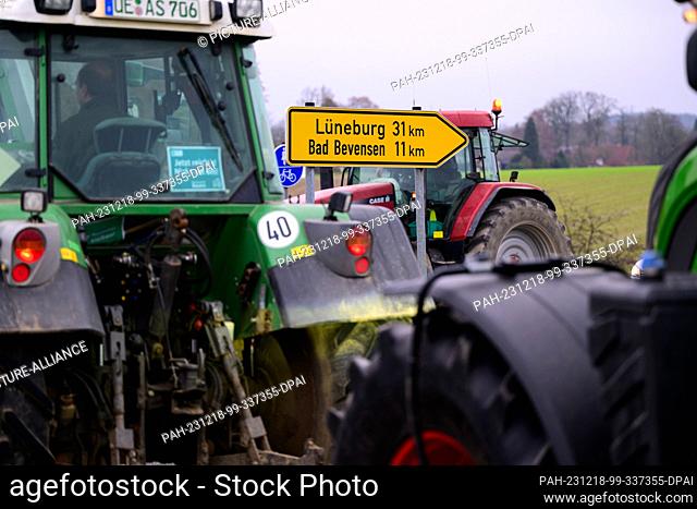 18 December 2023, Lower Saxony, Uelzen: Farmers drive their tractors at walking pace on federal highway 4 in response to the German government's plans to...