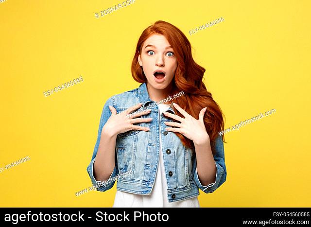 Close up Portrait young beautiful attractive redhair girl shocking with something. Golden yellow Background. Copy space