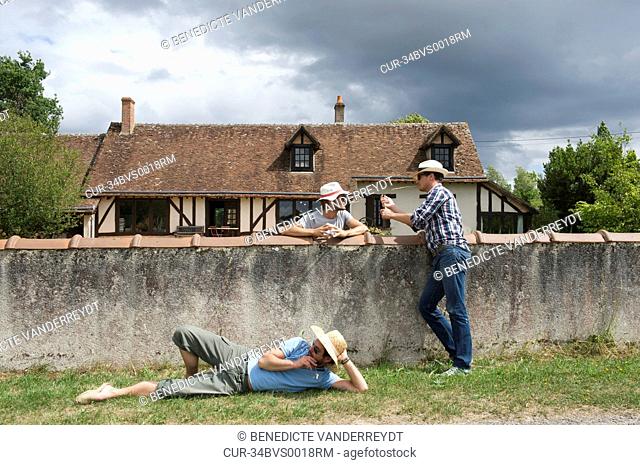 Men relaxing on rural wall