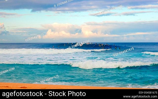 surfers catch waves during a morning session at pipeline on the north shore of oahu