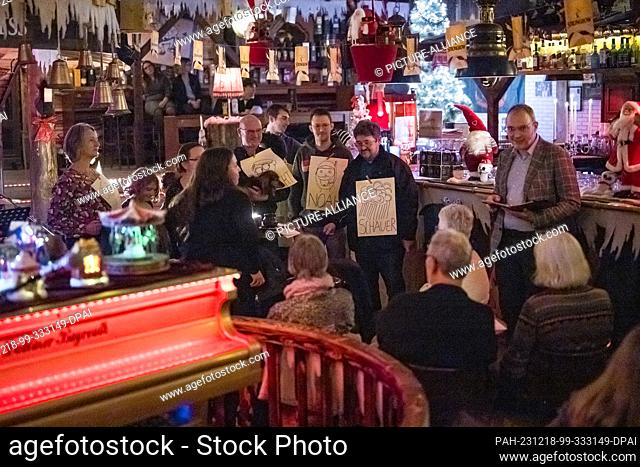 PRODUCTION - 17 December 2023, Bavaria, Bayreuth: Carsten Brall (r), pastor at the Stadtkirche Bayreuth, during the service in the Irish pub