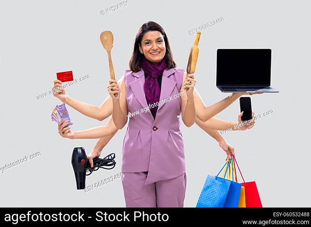 Portrait of a multitasking woman housewife with multiple hands holding various objects