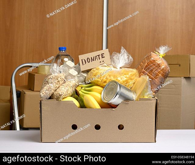 cardboard box with various products, fruits, pasta, sunflower oil in a plastic bottle and preservation. Donation concept